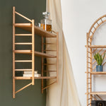 wall hung wooden ladder shelving by John Eadon on living room wall